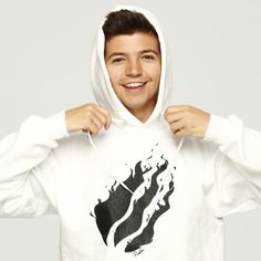 a man in a white hoodie is smiling and holding his hands on his hips