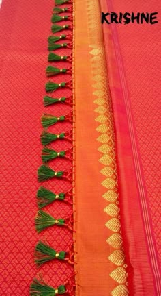 two rows of orange and green sari with tassels on the ends, one is