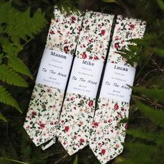 three ties with flowers on them sitting in the grass