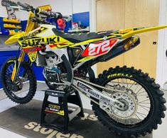 a yellow and black dirt bike sitting on top of a stand