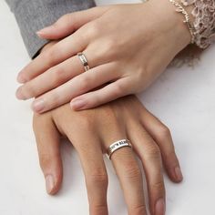 two people holding hands with wedding rings on their fingers