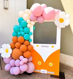 an orange and white vw bus with balloons on the front is decorated in pastel colors