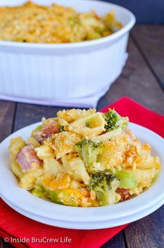 a white plate topped with broccoli casserole next to a red napkin