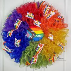 a wreath made out of tulle and rainbows on the front door for someone's birthday