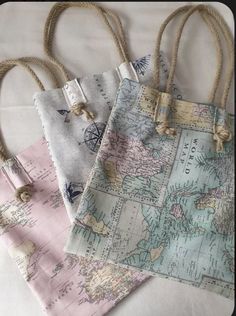 three bags with rope handles and maps on them