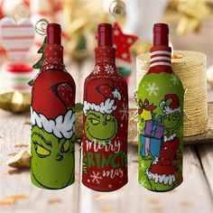 three christmas wine bottles sitting on top of a wooden table