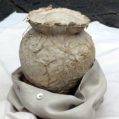 a large vase sitting on top of a white cloth