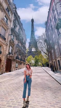 a woman standing in front of the eiffel tower with her hands on her hips