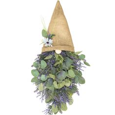 a hat with flowers and greenery hanging from it's side on a wall