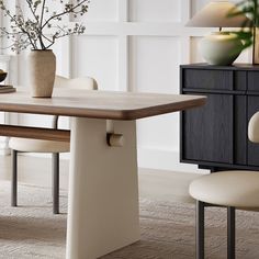 a dining room table with two chairs and a vase