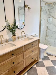 a bathroom with two sinks, a toilet and a shower