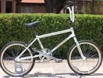 a white bicycle parked next to a hedge