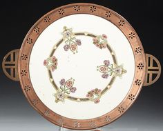 an ornately decorated plate with gold trimmings and pink flowers on the rim