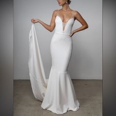 a woman in a white wedding dress holding up a white cloth