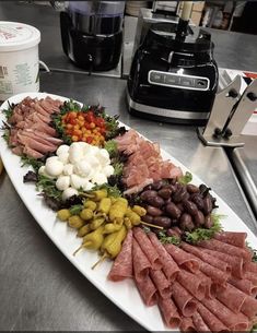 a platter filled with meats and vegetables on a counter