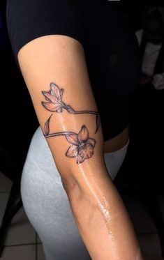 a woman's arm with a flower tattoo on the left side of her body