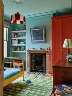 a bedroom with blue walls, green carpet and red bookcases in the corner