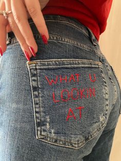 a woman's jeans with the words what i lookin at written on it