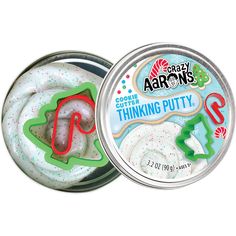 an open tin with white frosting and green sprinkles in it on a white background