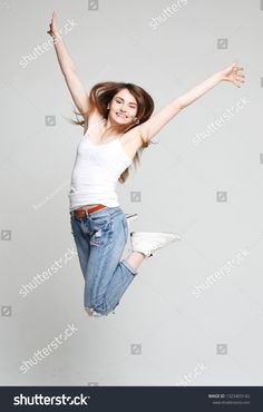 a young woman jumping in the air with her arms outstretched and legs spread wide open