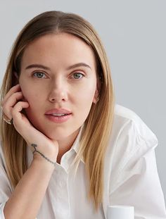 a woman sitting at a table with her hand on her chin and looking off to the side