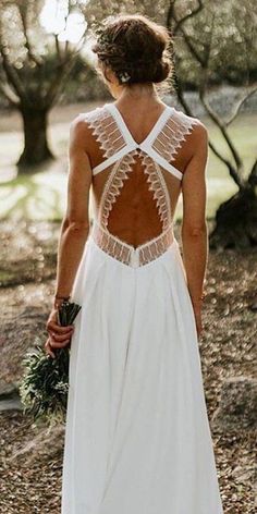 the back of a woman's wedding dress with an open back and crochet detailing