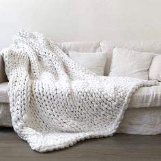 a white blanket sitting on top of a couch