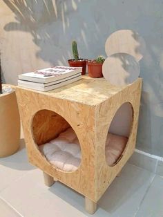 a small wooden table with some books on it and a buddha statue next to it