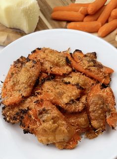 a white plate topped with cooked carrots and meat