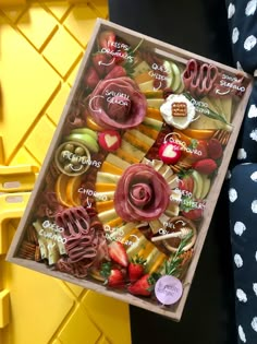 a box filled with lots of different types of food on top of a yellow table