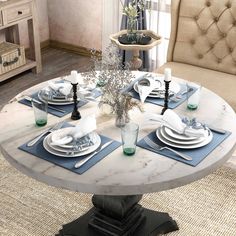 a dining room table set with place settings