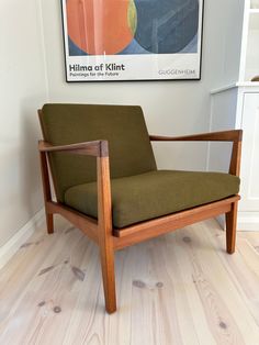 a green chair sitting on top of a hard wood floor next to a white wall