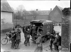 an old black and white photo of men loading items onto a truck