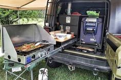 an open camper van with food cooking on the grill