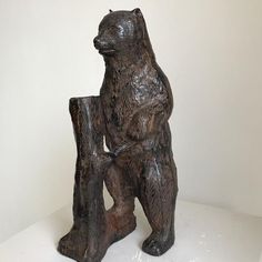 a statue of a bear holding a piece of wood