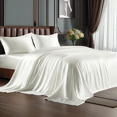 a bed with white sheets and pillows in a room