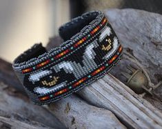 a beaded bracelet sitting on top of a piece of wood