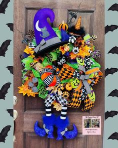 a halloween wreath on the front door decorated with witches and pumpkins, is hanging from a wooden door