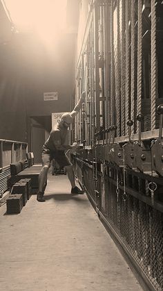 a man standing in front of a bunch of metal racks filled with boxes and other items