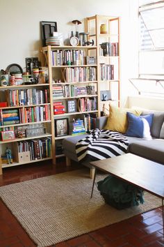 a living room filled with lots of books and furniture