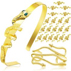 a gold snake bracelet and chain with blue eyes on it's head, next to the