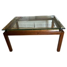 a glass top coffee table with wooden legs