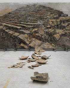 several pieces of wood sitting on the ground in front of a large stone structure with steps