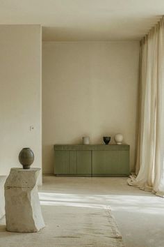 an empty room with two vases on the table