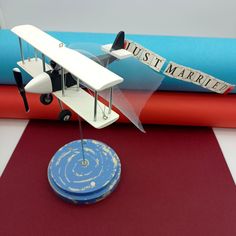 a small model airplane sitting on top of a red rug next to blue and orange books