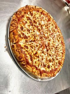 a large pizza sitting on top of a metal table