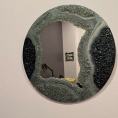 a round mirror hanging on the side of a wall