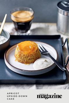 a plate with some cake on it next to two cups of coffee and spoons