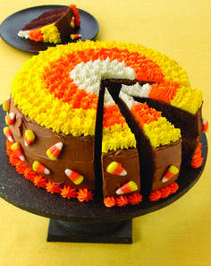 a cake that has been decorated with candy corn and chocolate frosting on the top