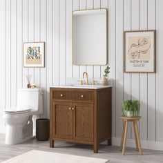 a white toilet sitting next to a wooden sink vanity in a bathroom under a mirror